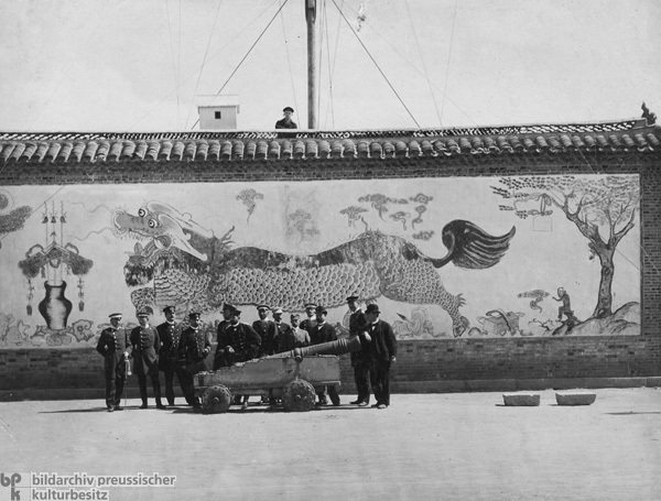 Deutsche Marineoffiziere posieren hinter einem chinesischen Geschütz (November 1897)